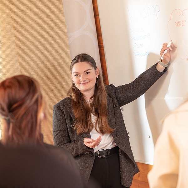Mitarbeiterin von HK Consulting hält Präsentation über Dokumenten-Digitalisierung und ECM-Lösungen am Whiteboard.