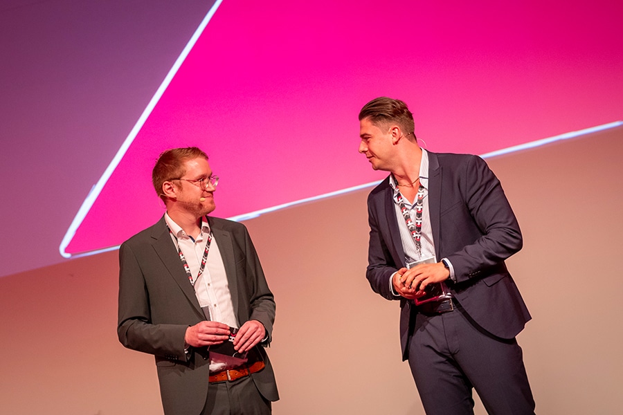 Zwei Geschäftsleute auf einer Konferenzbühne von HK Consulting, spezialisiert auf Dokumenten-Digitalisierung.